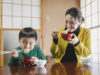 12 Essential Japanese New Year's Family Traditions Japanese family eating race cake on New Year's Day.