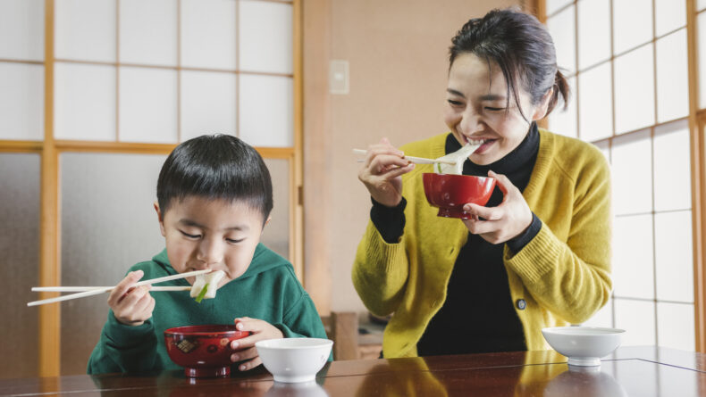 12 Essential Japanese New Year's Family Traditions Japanese family eating race cake on New Year's Day.