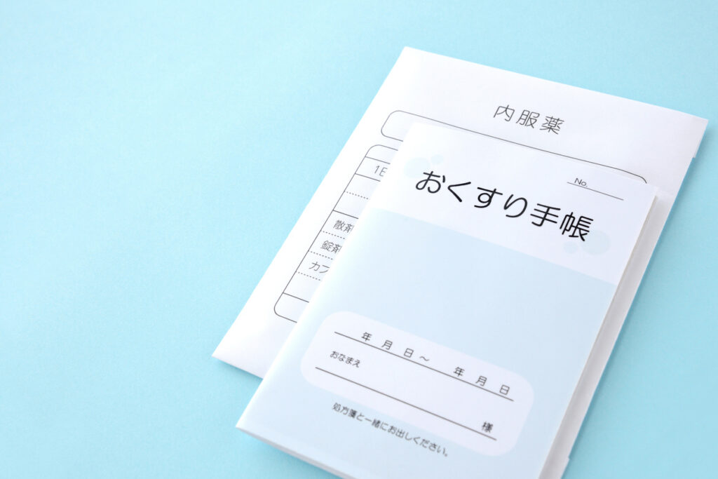 Japanese medical recording book and package for medicine on light blue background