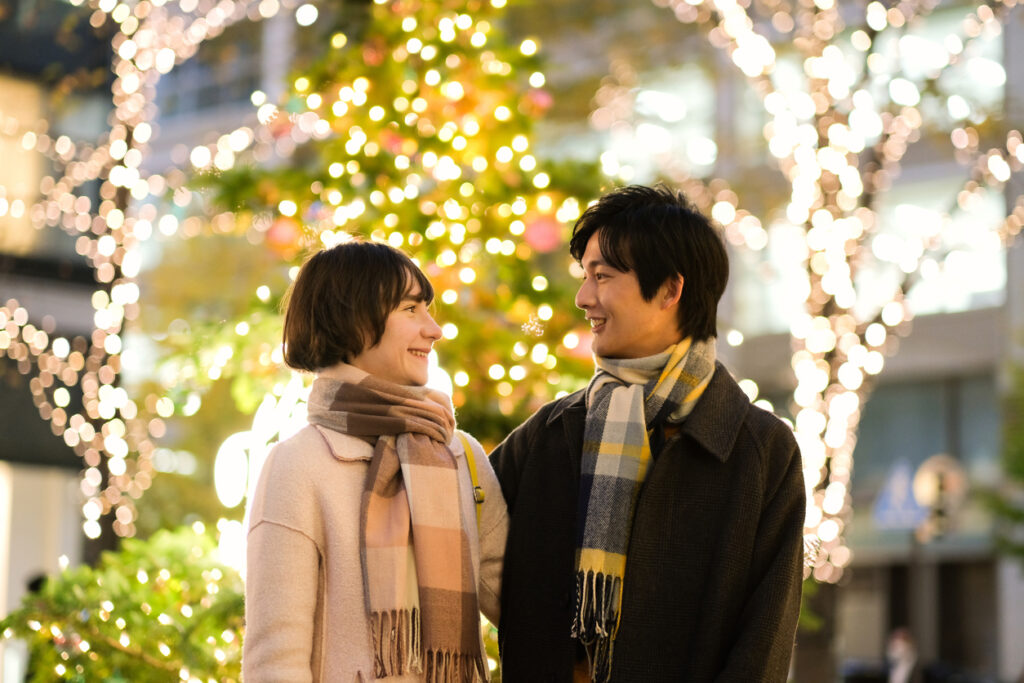 Ukrainian woman and Japanese man dating on the illuminated street in Christmas season