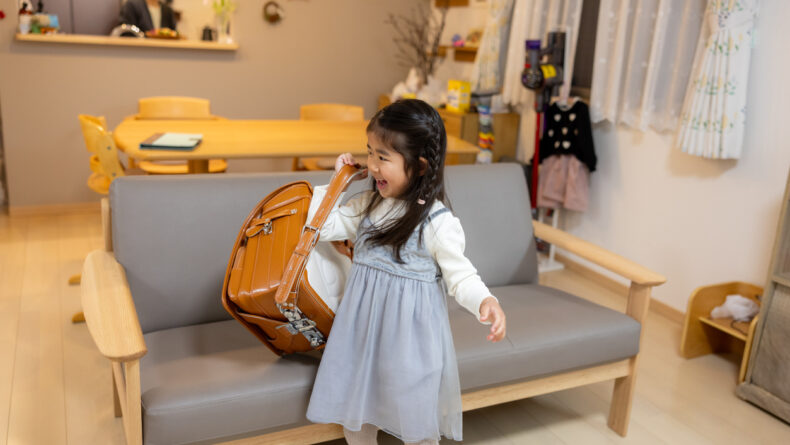 Little girl preparing for school, carrying randoseru