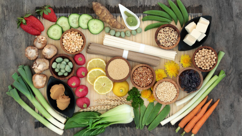 Macrobiotics health food concept with soba and udon noodles, wasabi and miso paste, tofu, vegetables, legumes, grains and seaweed with foods high in protein, antioxidants, vitamins and minerals. On bamboo and marble, top view.